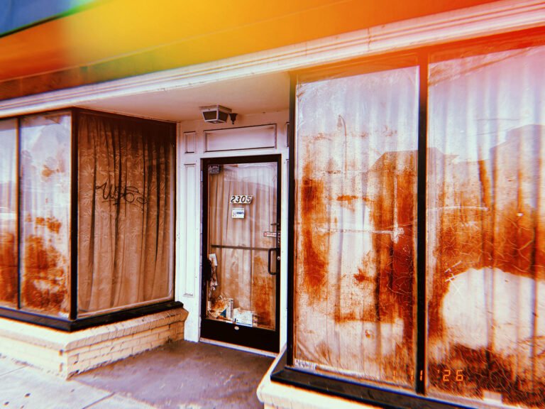 storefront entrance with number 2305 and stained windows covered by curtains in San Francisco