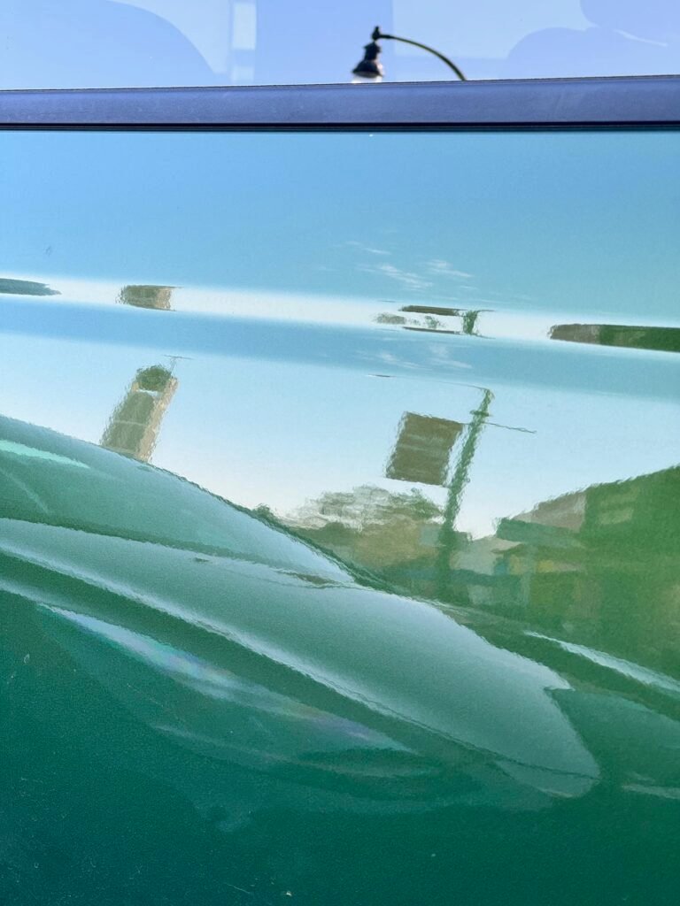 traffic lights and street scene reflected in green car door