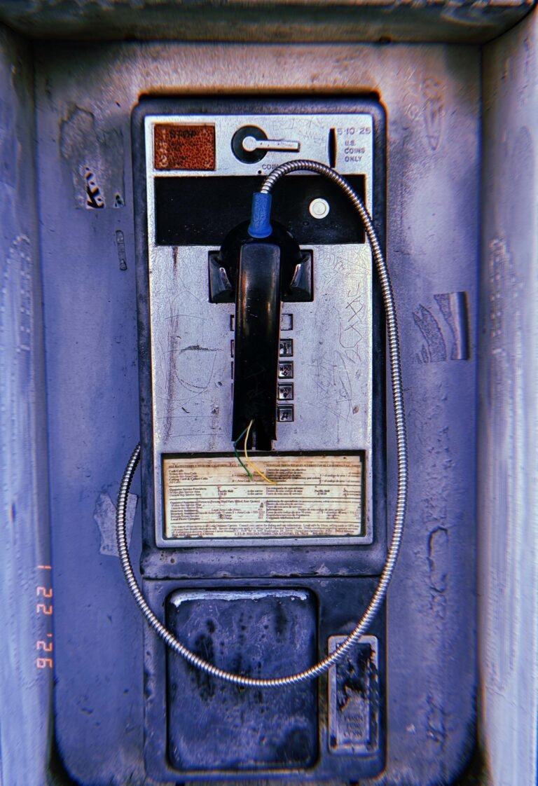 public payphone mounted inside a metal street enclosure