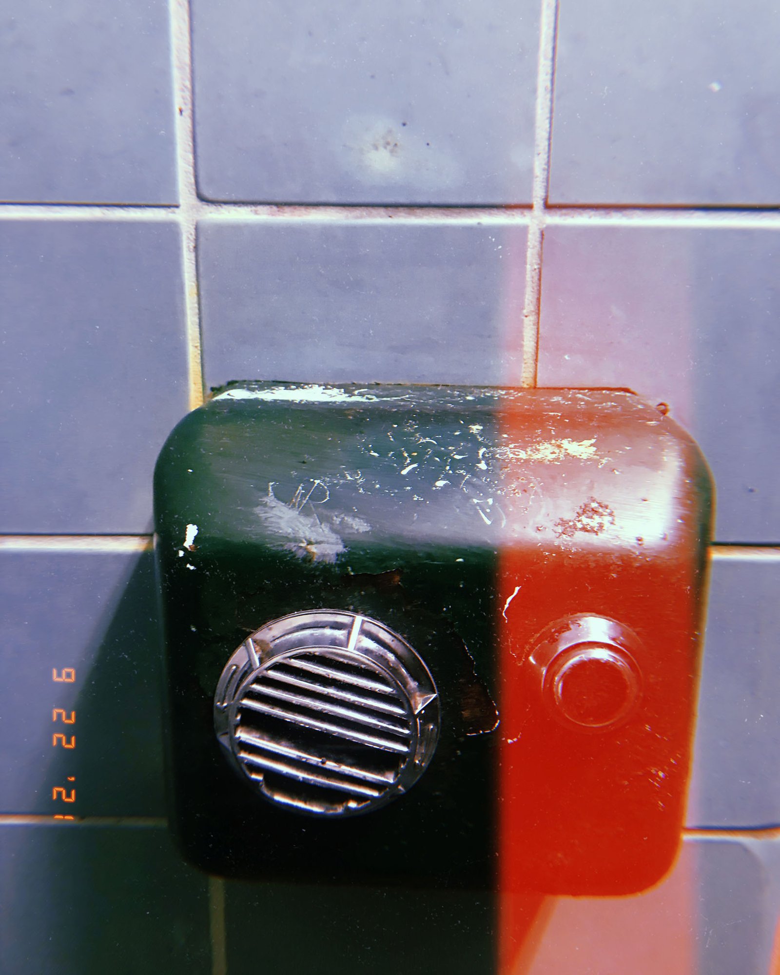 metal intercom speaker box mounted on tiled wall