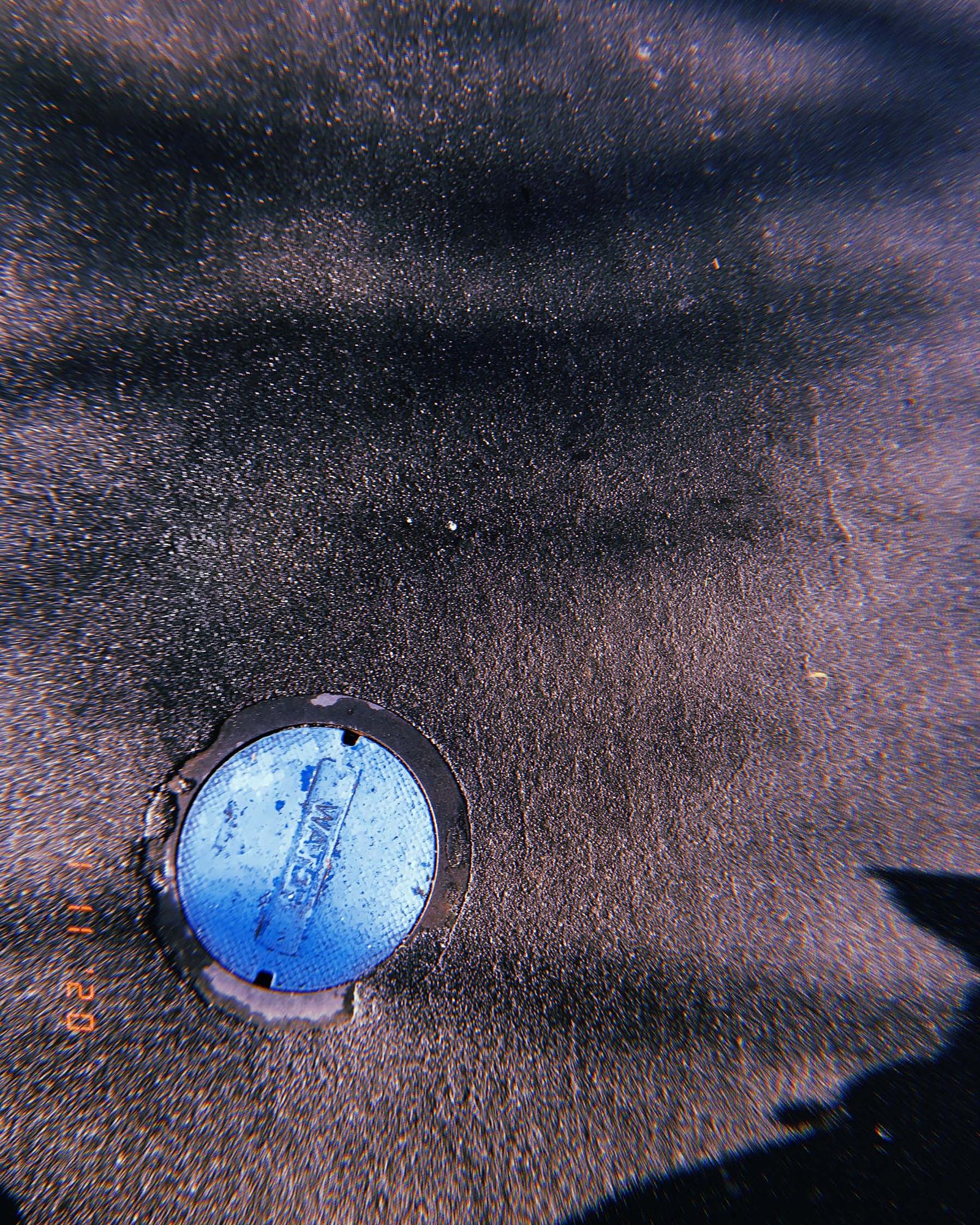 blue utility water cover embedded in asphalt surface in San Francisco