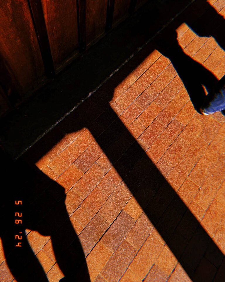 long shadows of pedestrians crossing textured brick sidewalk in san francisco