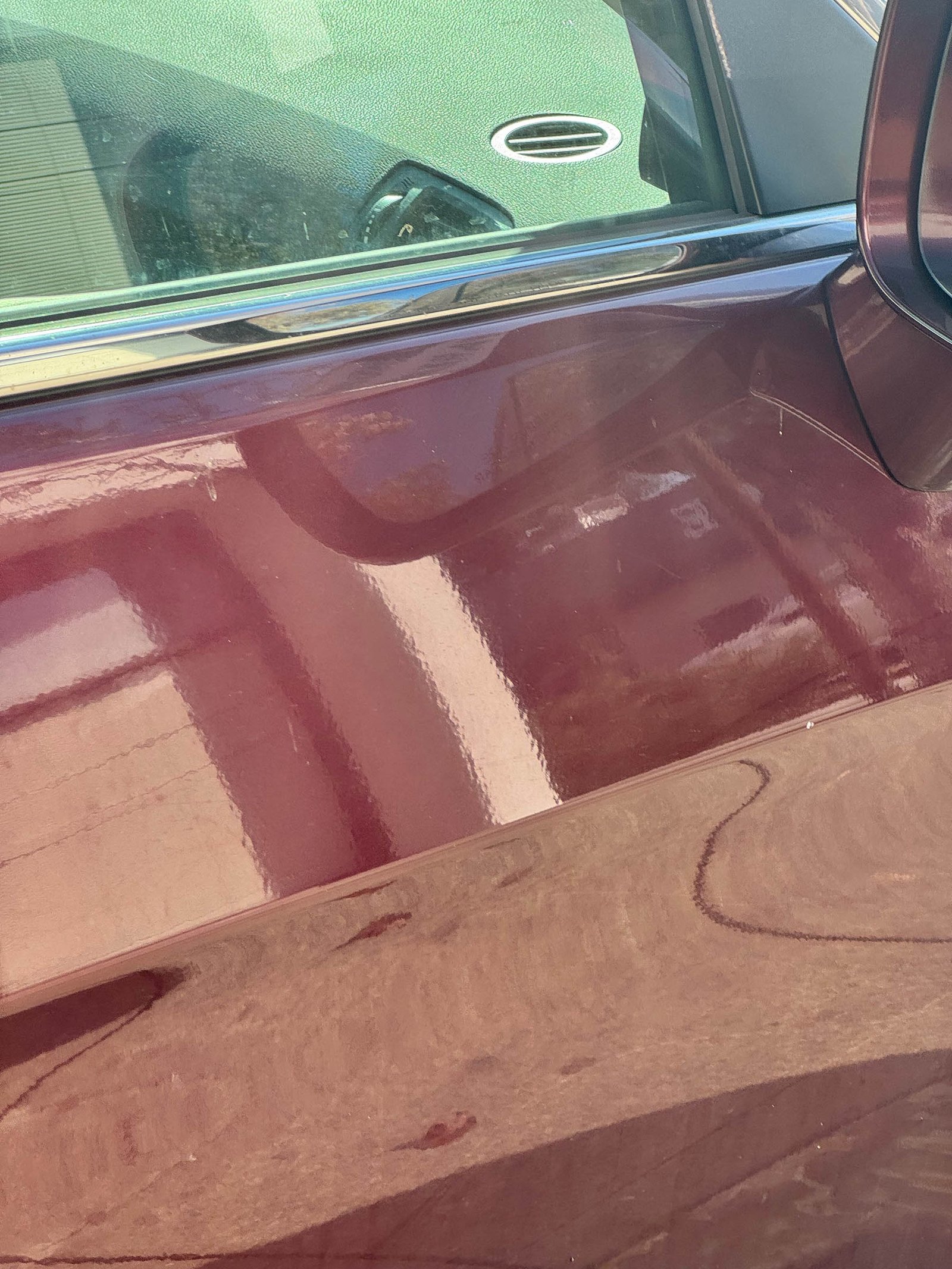 reflection of building windows and street in glossy car door surface