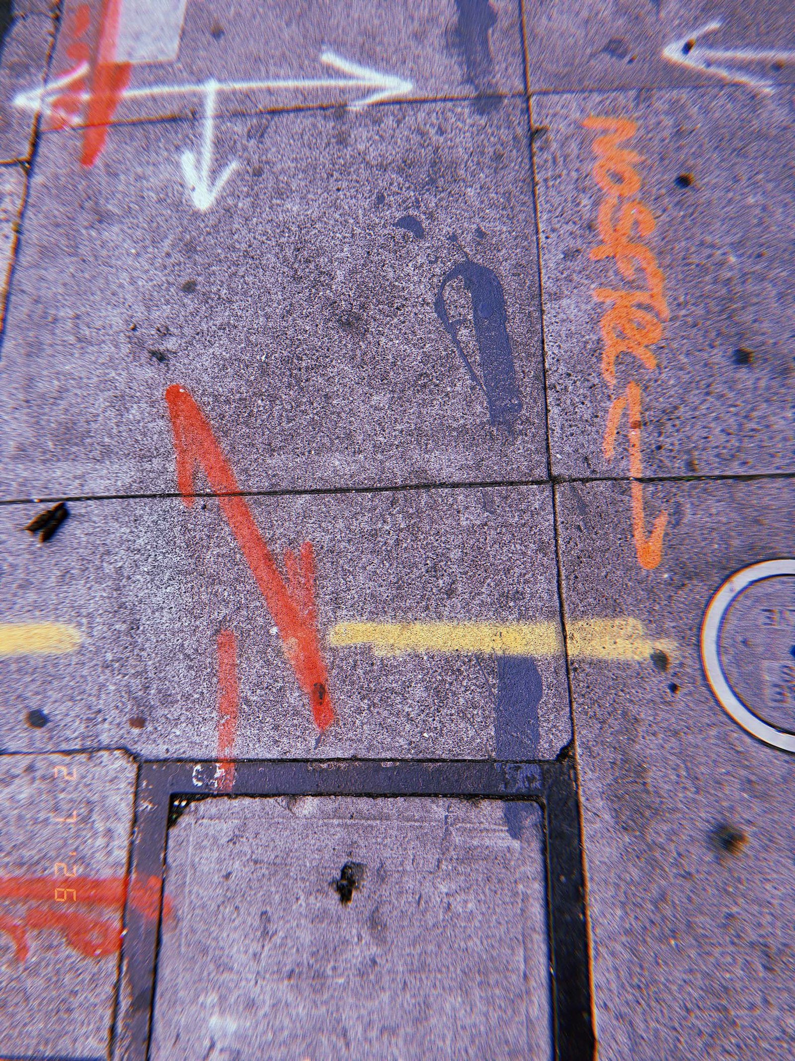 utility markings and directional arrows painted on sidewalk pavement