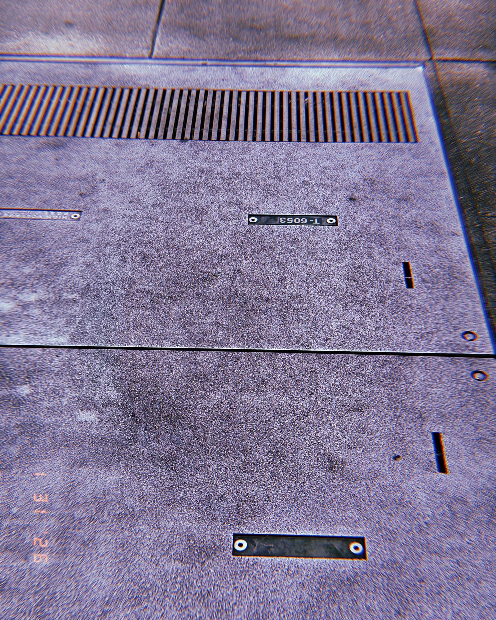 large concrete utility access panel with metal drainage grate above it
