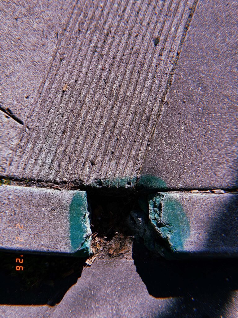 curb ramp with tactile grooves aligned with a painted green curb section