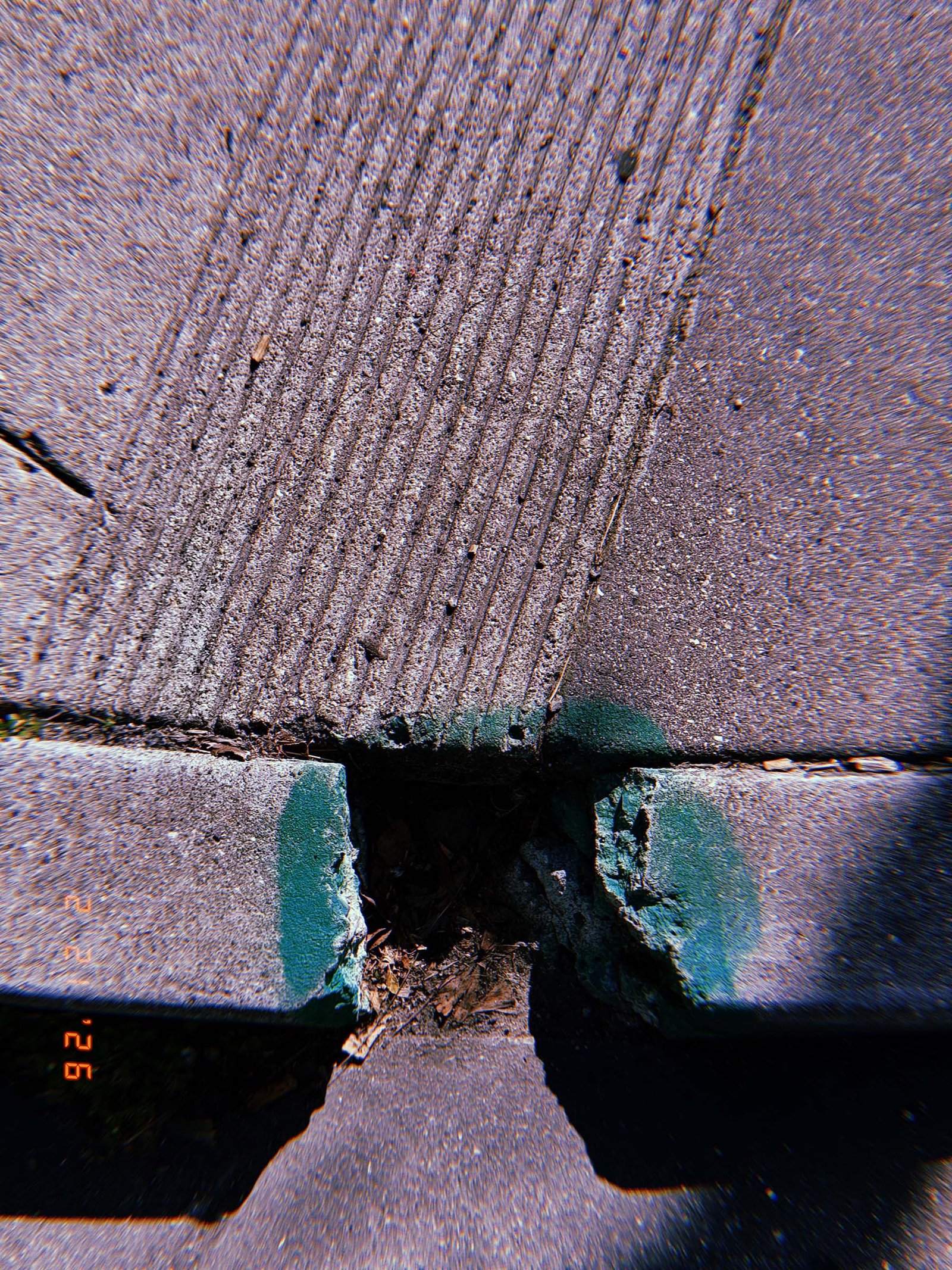 curb ramp with tactile grooves aligned with a painted green curb section