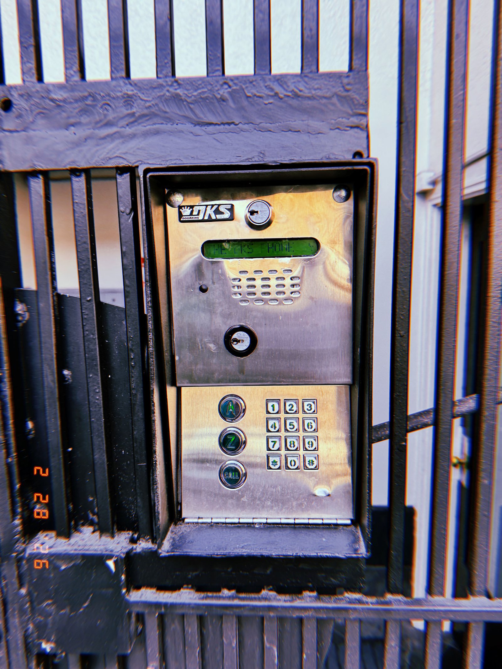 metal keypad entry and intercom unit installed in security gate frame