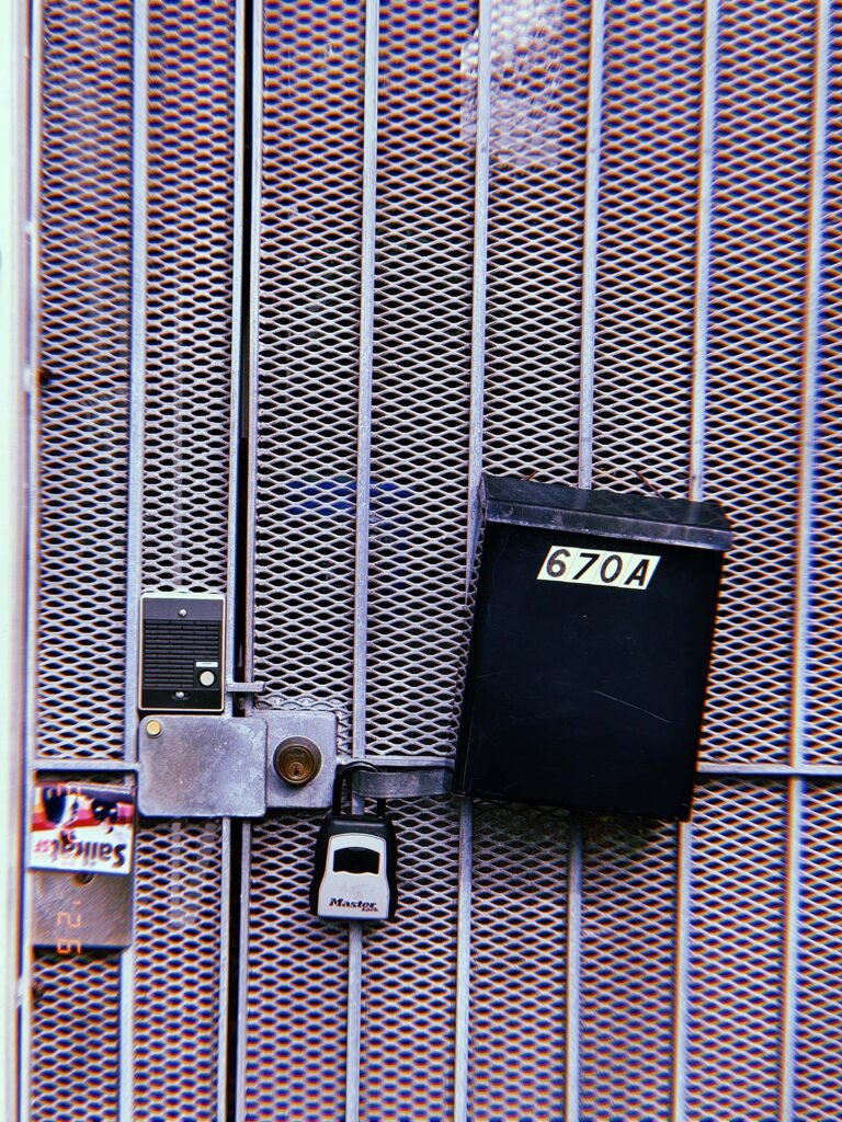 metal security gate with intercom button, lock mechanism, and address mailbox
