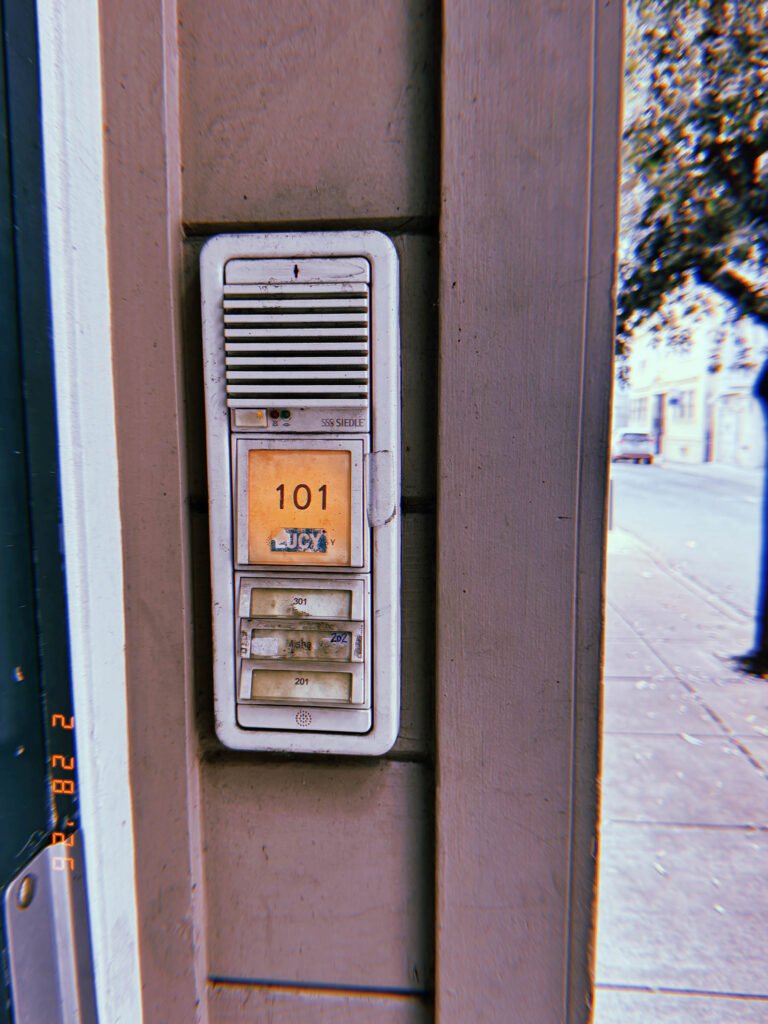building intercom entry panel with illuminated apartment number display