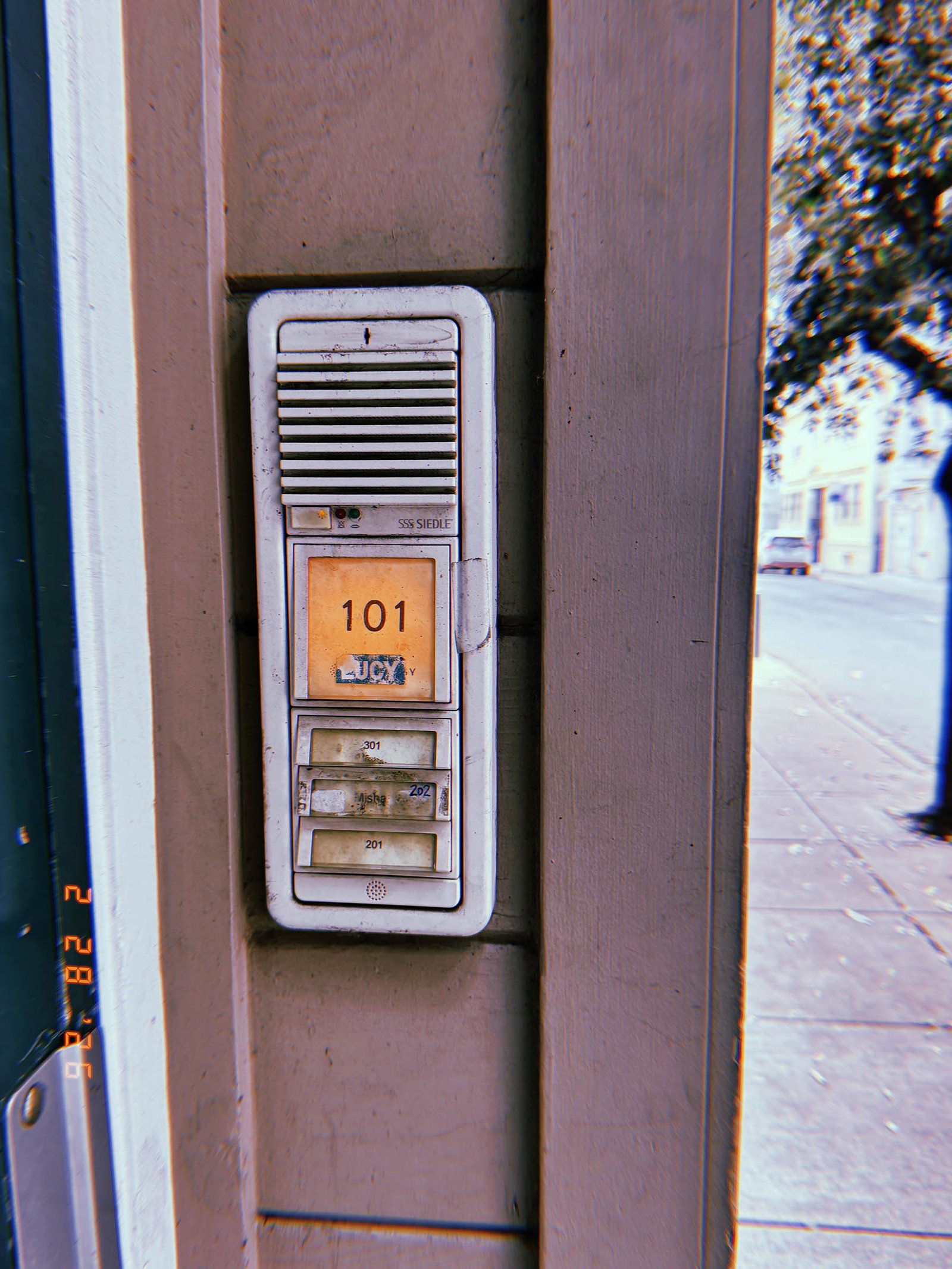 building intercom entry panel with illuminated apartment number display