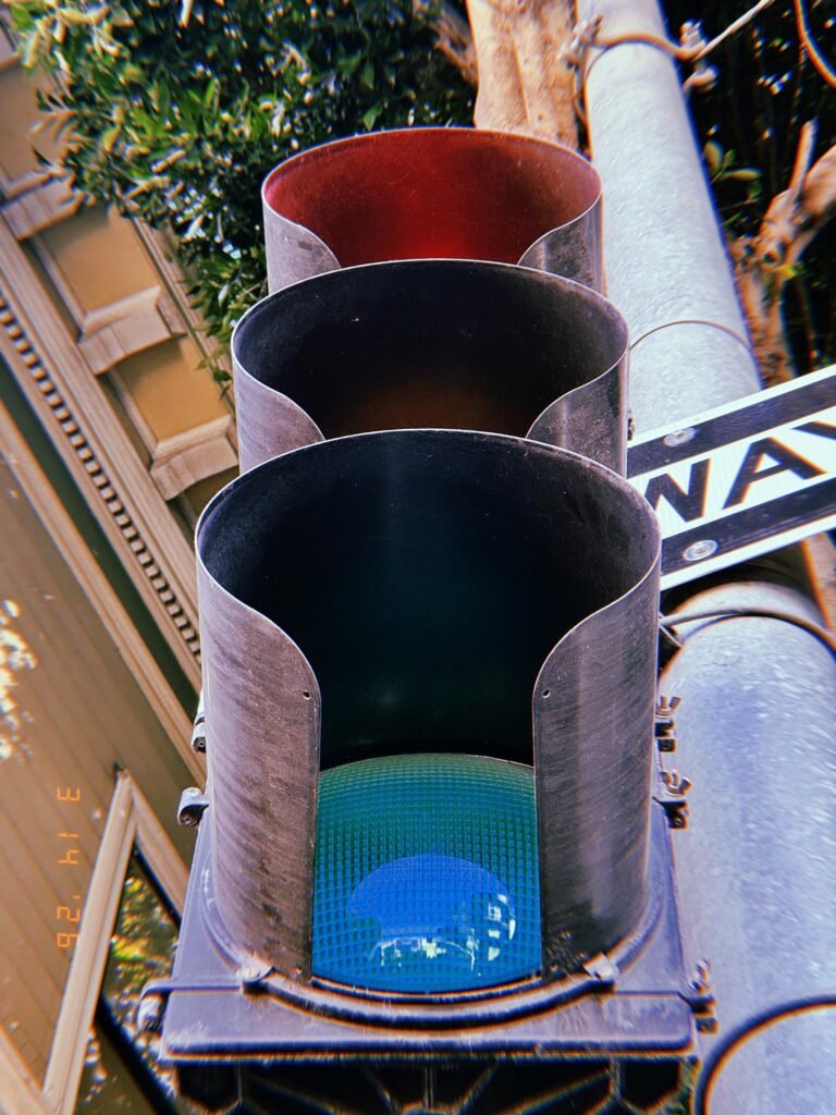 traffic signal with visible green light inside hooded visor mounted on pole