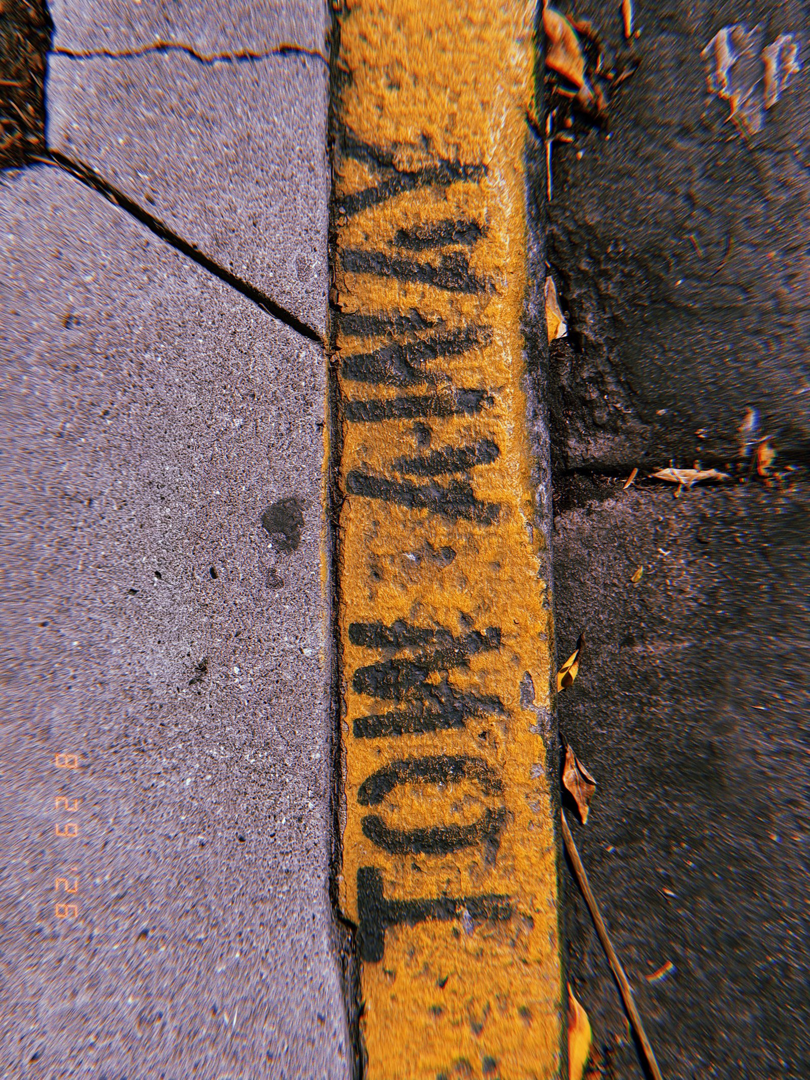 Black “COMMERCIAL LOADING” lettering painted on a worn yellow curb beside a concrete sidewalk.