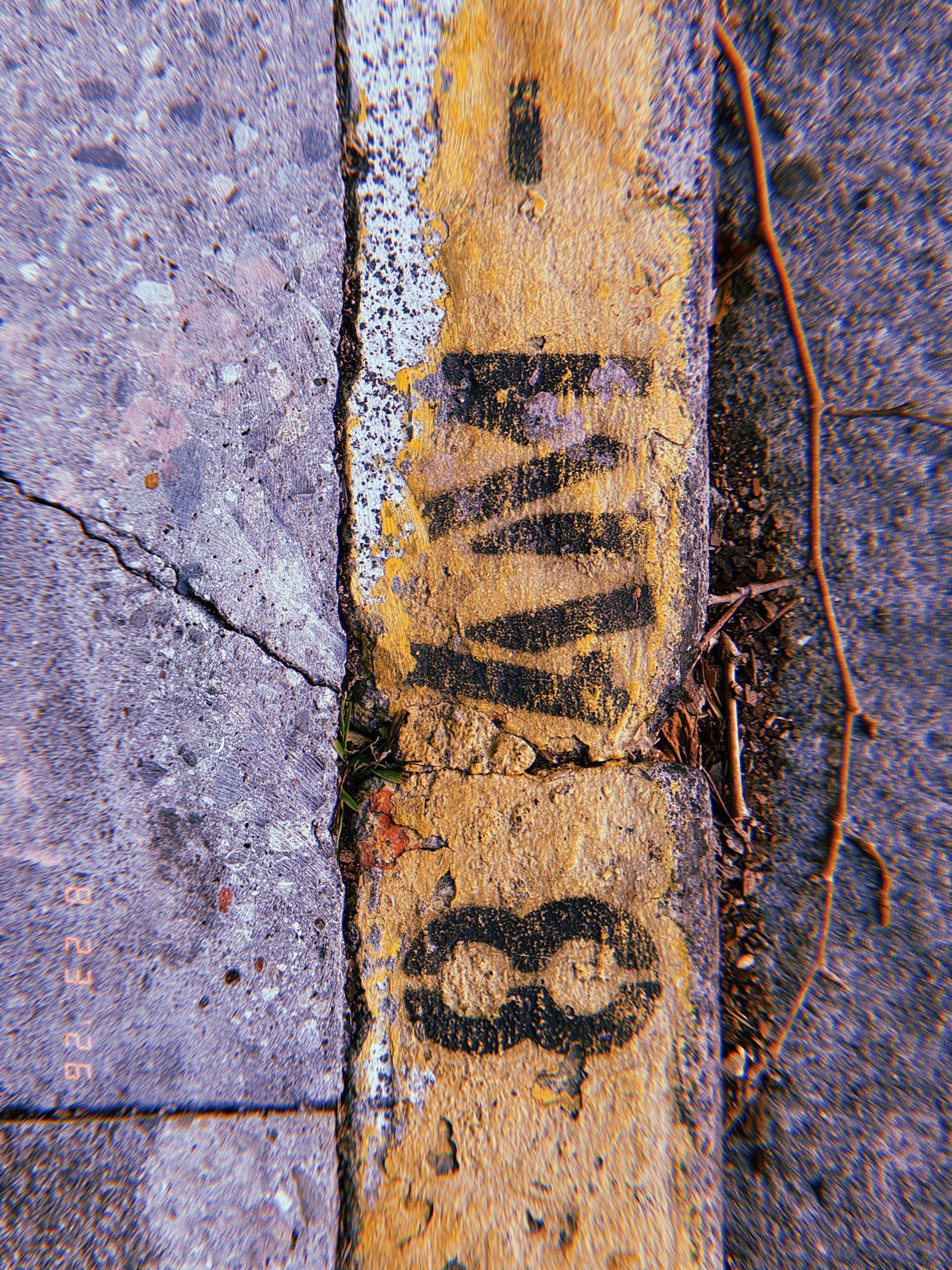 Black curb marking painted over a worn yellow curb beside a San Francisco sidewalk.